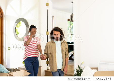 Young diverse couple holding hands, exploring new home, feeling excited and emotional 135677161