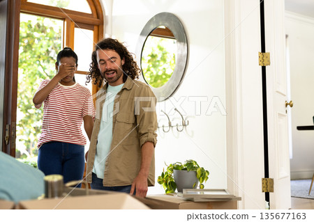 Young diverse couple unpacking boxes in new home, feeling excited and surprised Young diverse couple unpacking boxes in new home, feeling excited and surprised 135677163