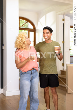 Young friends enjoying coffee together while unpacking in new home Young friends enjoying coffee together while unpacking in new home 135677218