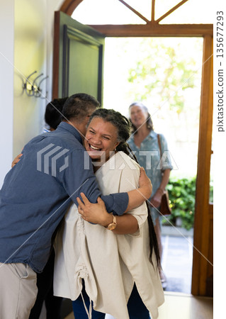 Senior people sharing joyful hugs and laughter, greeting warmly at home 135677293