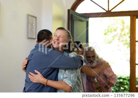 Senior friends embracing joyfully at home during warm, welcoming reunion Senior friends embracing joyfully at home during warm, welcoming reunion 135677296