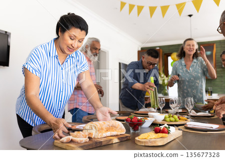 Preparing table with bread and wine, senior friends party at home Preparing table with bread and wine, senior friends party at home 135677328