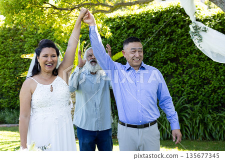 Celebrating wedding outdoors, senior couple holding hands and smiling joyfully Celebrating wedding outdoors, senior couple holding hands and smiling joyfully 135677345