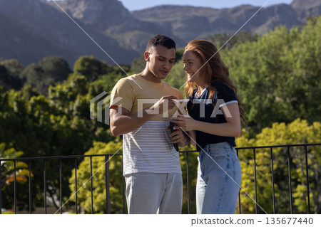 Young couple enjoying outdoor view, smiling and sharing moment together Young couple enjoying outdoor view, smiling and sharing moment together 135677440
