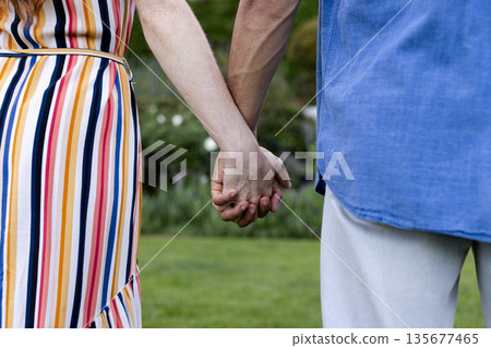 Holding hands outdoors, couple sharing peaceful moment together in park Holding hands outdoors, couple sharing peaceful moment together in park 135677465