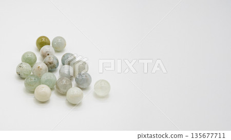 Multicolored aquamarine natural stone beads, macro photography on white background 135677711