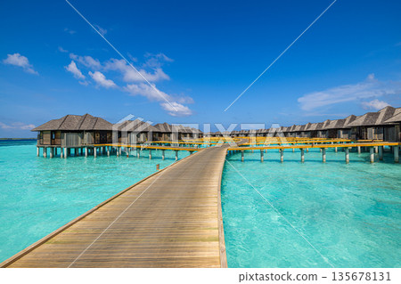 Luxury sunny Maldives island, overwater villas and bungalows, calm turquoise lagoon, tropical paradise, relaxing summer vacation, serene exotic travel destination 135678131