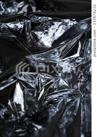 Vertical crumpled foil texture with strong metallic contrast 135678210
