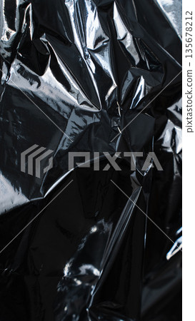 Dark silver foil texture with angular folds and glossy highlights Dark silver foil texture with angular folds and glossy highlights 135678212