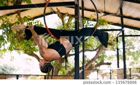 Woman practising aerial hoop acrobatics in costa rica Woman practising aerial hoop acrobatics in costa rica 135678806