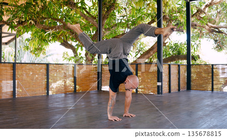 Man performing handstand while training fitness in costa rica 135678815