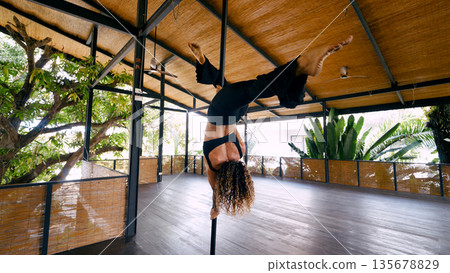 Aerial dancer practicing pole fitness in costa rica Aerial dancer practicing pole fitness in costa rica 135678829