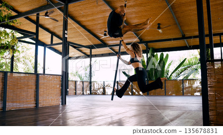 Couple performing aerial pole fitness in costa rica studio 135678831