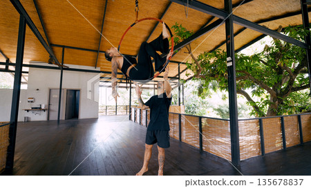 Aerial dancers performing lyra training in tropical studio Aerial dancers performing lyra training in tropical studio 135678837