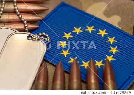 Ammunition and army tags on blue fabric with European Union symbols. 135679259