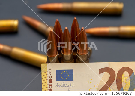 Close up of ammunition on euro banknote with European Union symbol. Close up of ammunition on euro banknote with European Union symbol. 135679268