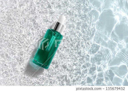 Cosmetic bottle on the water surface. Blank label for branding mock-up. Summer water pool fresh concept. Flat lay, top view. 135679432