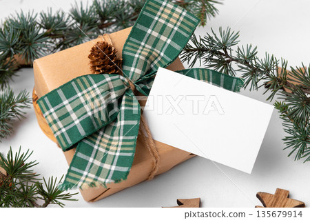 Christmas rectangle gift tag mockup with present box on white wooden background 135679914