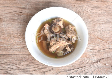 boiled pork bone topping black mushroom in clear Chinese herb soup on bowl boiled pork bone topping black mushroom in clear Chinese herb soup on bowl 135680478