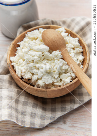 Cottage cheese in wooden bowl with spoon Cottage cheese in wooden bowl with spoon 135680612