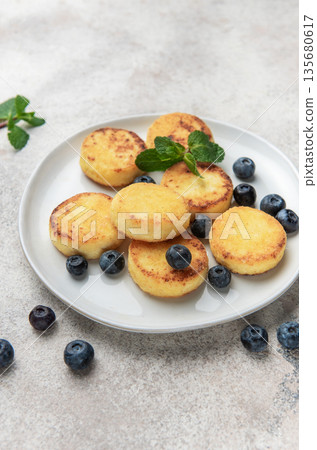Syrniki cottage cheese pancakes with blueberries and mint 135680617