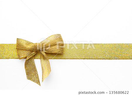 Gold ribbon bow creating a festive background decoration 135680622