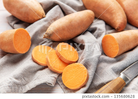 Raw sliced sweet potato preparation on rustic cloth 135680628