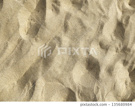 Golden sand texture in closeup, forming natural ripples under bright sunlight. Abstract beach 135680984
