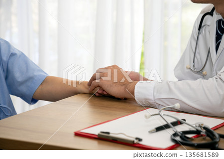 Close-up of doctor compassionately holding elderly patient hand during a consultation. Represents trust, care, empathy, and emotional support in healthcare for seniors Close-up of doctor compassionately holding elderly patient hand during a consultation. Represents trust, care, empathy, and emotional support in healthcare for seniors 135681589