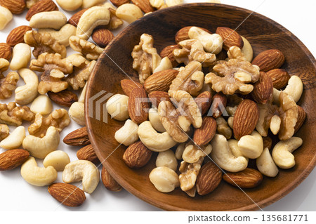 Mixed nuts in a wooden bowl Mixed nuts in a wooden bowl 135681771
