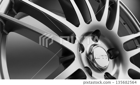 Close up of a metallic silver and black car alloy wheel rim with detailed mechanical spokes and brushed texture 135682564