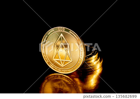 EOS coin cryptocurrency. Gold coins on black background. 135682699