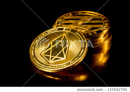 EOS cryptocurrency. Gold coins on black background. EOS cryptocurrency. Gold coins on black background. 135682700