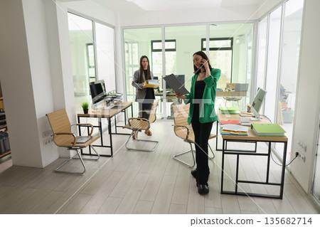 Busy professionals collaborating in a modern office space during a productive day at work Busy professionals collaborating in a modern office space during a productive day at work 135682714