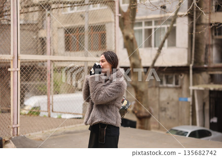 Woman sipping coffee in a cozy urban setting during a chilly afternoon Woman sipping coffee in a cozy urban setting during a chilly afternoon 135682742