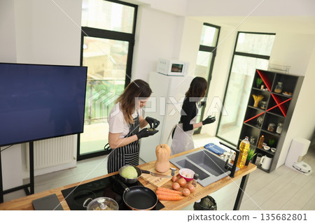 Cooking in a modern kitchen as two chefs prepare fresh ingredients for a delightful meal together 135682801