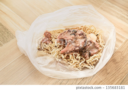 將罐裝鯖魚和乾白蘿蔔混合在一個塑膠袋中。 將罐裝鯖魚和乾白蘿蔔混合在一個塑膠袋中。 135683181