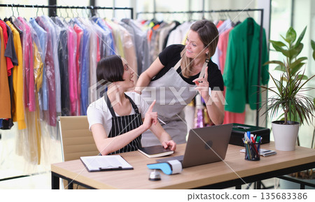 Engaging interaction between staff in a vibrant clothing store during a busy afternoon Engaging interaction between staff in a vibrant clothing store during a busy afternoon 135683386