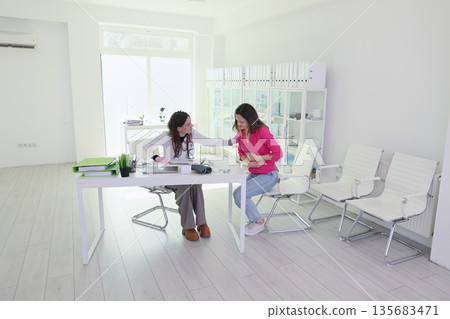 Caring doctor provides comfort and guidance to patient in a modern clinic setting 135683471