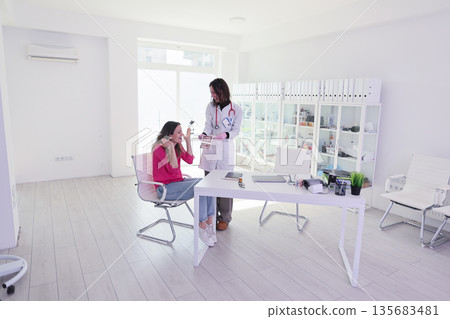 Health consultation in a bright and modern clinic with a doctor and patient engaging in a friendly discussion 135683481