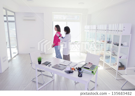 Health checkup in a bright, modern clinic with caring professionals and welcoming atmosphere 135683482