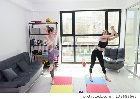 Friends enjoying a lively workout session in a bright and spacious living room filled with energy and motivation Friends enjoying a lively workout session in a bright and spacious living room filled with energy and motivation 135683665