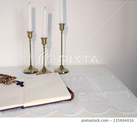 Catholic corner at home. Wooden rosary beads, cross, and prayer book. Faith, symbols, and traditions. 135684016