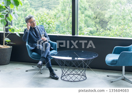 Middle-aged businessman drinking alcohol at a dinner party Middle-aged businessman drinking alcohol at a dinner party 135684083