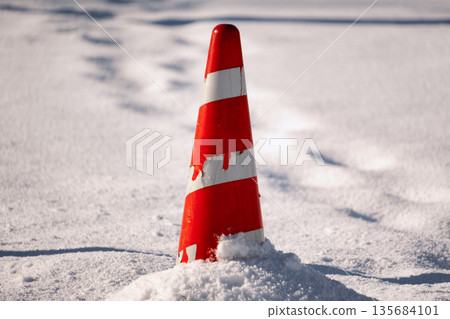 Red traffic cones buried in the snow Red traffic cones buried in the snow 135684101