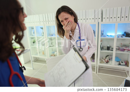 Laughter and teamwork fill the veterinary clinic during a busy afternoon of caring for animals 135684173