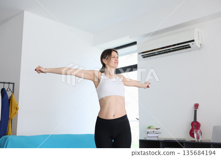 Embracing positivity in a bright living space during the morning stretch 135684194