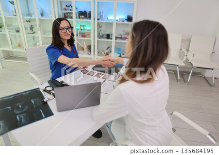 Health consultation in a modern clinic with a friendly doctor and patient discussing treatment options together Health consultation in a modern clinic with a friendly doctor and patient discussing treatment options together 135684195