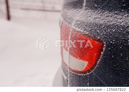 Snow-Covered Car Tail Light in Winter Landscape with Frosty Texture and Red Accents 135687822