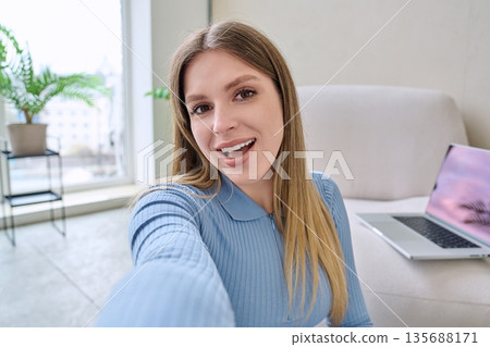 Selfie portrait happy beautiful young woman in home interior Selfie portrait happy beautiful young woman in home interior 135688171